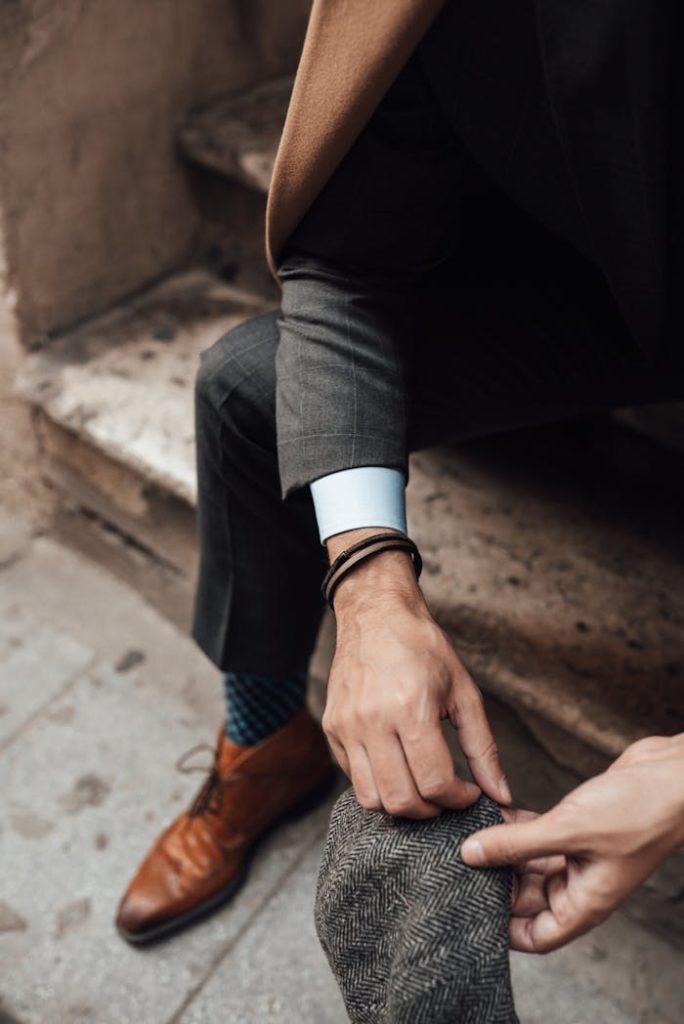 Crop stylish man sitting on stairs